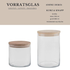 May include: Two clear glass storage jars with wooden lids. The jars are cylindrical, one smaller and one larger. The text on the top of the image says "VORRATSGLAS" and "(OHNE DEKO)". The text also says "KURZ & KNAPP" and "Holzdeckel aus Buche".