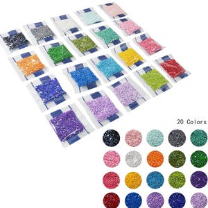May include: Twenty small bags of colorful diamond painting drills, each bag containing a different color. The colors include black, white, pink, orange, green, blue, purple, and red.  20 Colors.