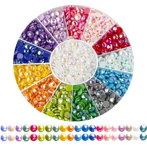 May include: A round container with 12 compartments filled with colorful iridescent rhinestones. Each compartment has a different color of rhinestones, including white, blue, green, yellow, orange, red, pink, and purple.