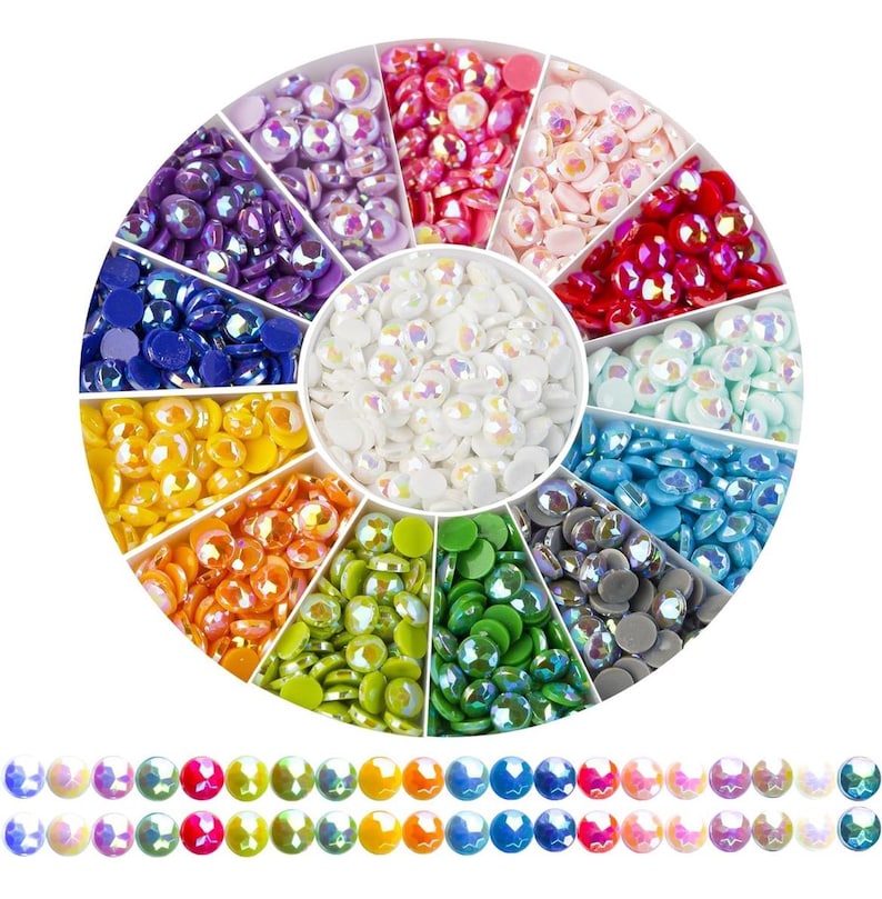 May include: A round container with 12 compartments filled with colorful iridescent rhinestones. Each compartment has a different color of rhinestones, including white, blue, green, yellow, orange, red, pink, and purple.