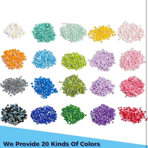 May include: Twenty different colors of round, flat-backed rhinestones, each color shown in a small pile.