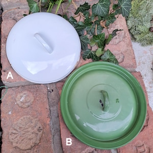 Puede incluir: Dos tapas de olla de esmalte, una blanca y otra verde, con asas negras. Las tapas están etiquetadas con "A" y "B" en la imagen.