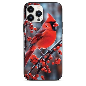 May include: A red cardinal bird perched on a branch with red berries against a snowy background. The bird has a black head and a long, pointed beak. The image is suitable for phone cases.