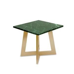 Könnte beinhalten: Ein quadratischer Beistelltisch mit einer grünen Marmorplatte und goldfarbenen Metallbeinen. Der Tisch hat ein modernes Design, wobei die Beine am Boden eine X-Form bilden. Die Marmorplatte hat ein natürliches Aderungsmuster.