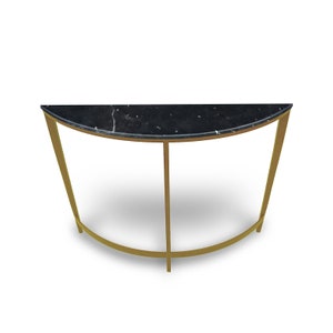Op de afbeelding: Een halfronde consoletafel met een zwart marmeren blad en een gouden metalen frame.