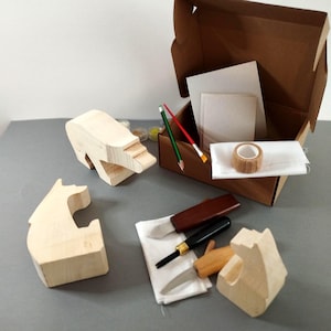 Puede incluir: Un kit de manualidades con formas de animales de madera, herramientas para tallar, pinceles, lápices y cinta adhesiva. El kit incluye una caja de cartón con papel y otros suministros. Las formas de animales de madera no están pintadas.