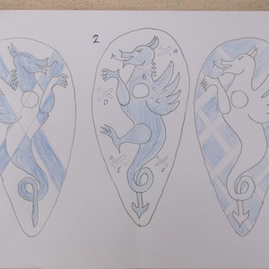 Puede incluir: Tres diseños de escudos azules y blancos con una ilustración de dragón. Los escudos están numerados del 1 al 3. El dragón del escudo 2 tiene las letras A, B, C, D, E y F.