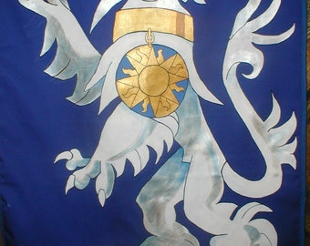 Puede incluir: Un león heráldico blanco con un collar de oro y un escudo azul y dorado en forma de sol sobre un fondo azul.