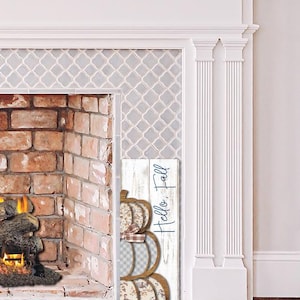 May include: A wooden sign with three stacked pumpkin designs in fall colors. The pumpkins have different patterns, including plaid and floral prints. The sign reads "Hello, Fall" in cursive.