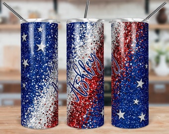Puede incluir: Tres vasos de acero inoxidable con un diseño de purpurina rojo, blanco y azul. Los vasos están decorados con estrellas y la palabra "Ashley" está escrita en uno de los vasos.
