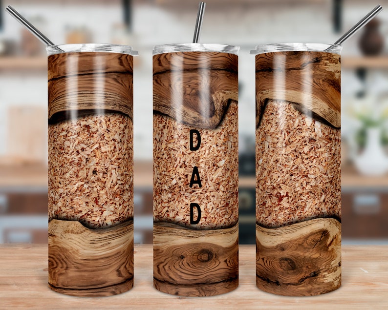 May include: Three stainless steel tumblers with a wood grain design. The middle tumbler has the word "DAD" printed on it.