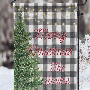 May include: A black and white buffalo plaid garden flag with a green Christmas tree and white lights. The text "Merry Christmas The Smiths" is written in red cursive.