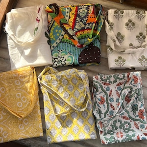 May include: Six tote bags with different patterns. The bags are made of white cotton fabric with colorful printed designs. The designs include floral patterns, geometric patterns, and abstract patterns.