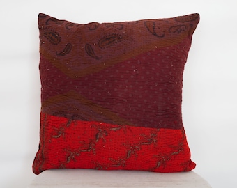 May include: A red and brown patterned throw pillow with a quilted design. The pillow is made from recycled saris and has a unique, handmade look.