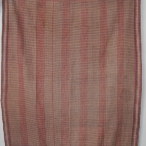 May include: A rectangular textile featuring a woven pattern of vertical stripes in muted shades of tan, beige, and dusty rose. The fabric displays a visible cross-hatched texture throughout, with darker purple-toned borders along the edges.