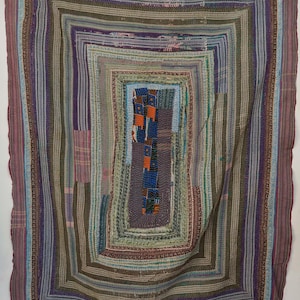 Peut inclure: Une pièce textile rectangulaire avec un motif géométrique imbriqué. La pièce présente une variété de couleurs, dont le violet, le bleu, le vert et le marron, disposées en rectangles concentriques. Les bords sont d'une nuance de violet plus foncée.