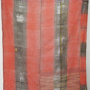 May include: A red and gray kantha quilt with a patchwork design. The quilt is made of recycled saris and has a variety of textures and patterns.
