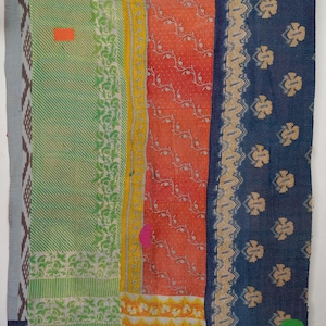 May include: A rectangular textile quilt featuring vertical panels of varying colours and patterns. The design includes green diagonal stripes, a central orange section with white vine motifs, and a dark blue side panel with beige floral prints.