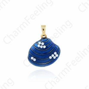 May include: A blue seashell pendant with white pearl accents. The pendant is made of metal and has a gold finish.