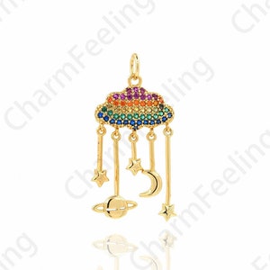 Peut inclure: Un pendentif de charme en or représentant un nuage arc-en-ciel avec des étoiles, une lune croissante et une planète suspendues. Le charme est en métal et a une finition brillante.