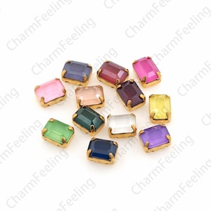 Può includere: Assortimento di 13 piccoli strass rettangolari in vetro con montature dorate. Gli strass sono di vari colori, tra cui rosa, viola, verde, blu, rosso e trasparente.