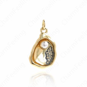 May include: A gold-tone oyster shell charm with a white pearl inside. The charm has a detailed design and is perfect for adding a touch of elegance to any jewelry piece.
