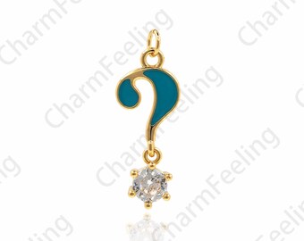 Könnte beinhalten: Goldener Anhänger in Form eines Fragezeichens mit blauer Emaille-Oberfläche und einem klaren Strassstein, der unten hängt.