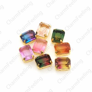 Puede incluir: Surtido de gemas de vidrio rectangulares de colores con engastes dorados. Las gemas son de varios tonos de rosa, morado, verde, naranja y marrón.