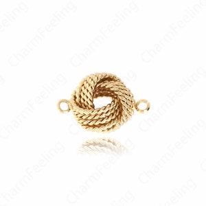 Puede incluir: Un charm de nudo dorado con dos anillos de salto para sujetarlo a un collar o pulsera.