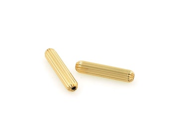 May include: Two gold-colored metal end caps with a ribbed texture. The end caps are about 1 inch long.