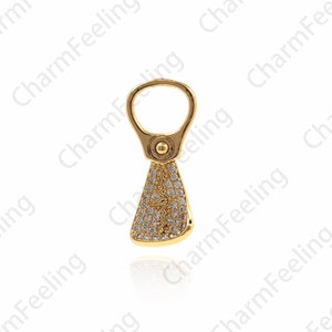 Può includere: Un ciondolo color oro con un anello nella parte superiore e una base triangolare. La sezione inferiore è incastonata con piccoli cristalli trasparenti. Il ciondolo è progettato per la creazione di gioielli.