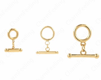 May include: Three gold-toned toggle clasps with a round ring and a straight bar. The clasps are different sizes.