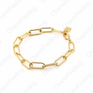 May include: A gold chain bracelet with a simple, linked design. The bracelet is made of a thick, durable metal and has a polished finish.