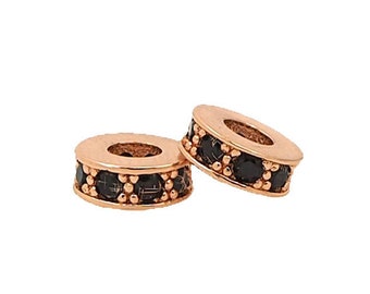 May include: Two gold-toned spacers with black gemstones. The spacers are round and have a smooth surface. They are perfect for adding a touch of elegance to your jewelry.