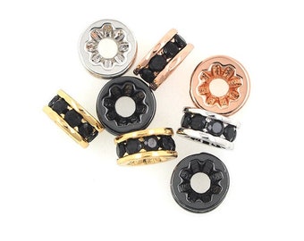May include: Assortment of small round metal beads with black crystal accents. The beads are in silver, gold, and rose gold tones.
