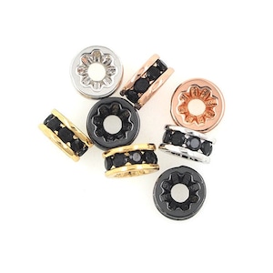 May include: Assortment of small round metal beads with black crystal accents. The beads are in silver, gold, and rose gold tones.