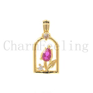 May include: Gold-tone pendant charm featuring a pink rose with clear crystal accents inside a gold-tone frame.