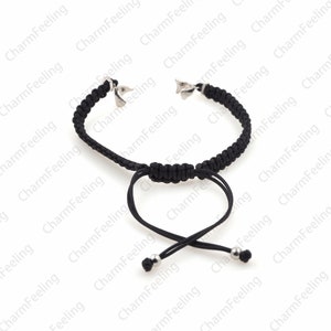 Puede incluir: Un brazalete negro ajustable con cierres y cuentas de metal plateado. El brazalete est&aacute; hecho de cord&oacute;n trenzado y tiene un dise&ntilde;o simple.