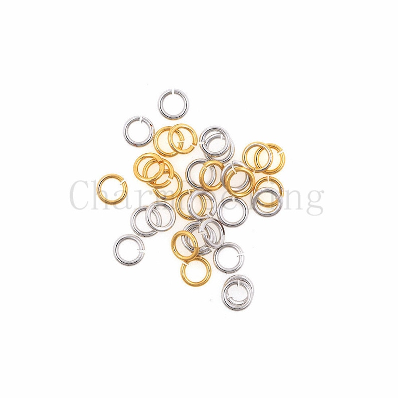May include: A pile of gold and silver jump rings. The jump rings are small and round, and they are perfect for jewelry making.