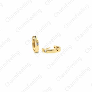 Peut inclure: Une paire de boucles d'oreilles cr&eacute;oles en or avec une petite pierre transparente sertie dans chaque cr&eacute;ole.