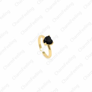 May include: A gold adjustable ring with a black heart-shaped stone.