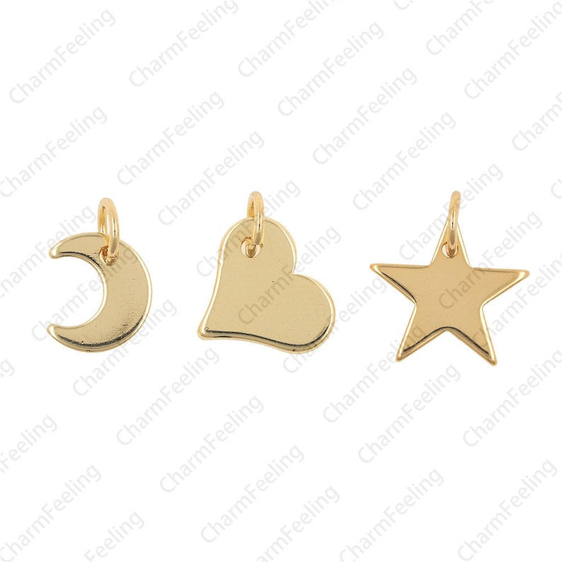 May include: Three gold-coloured metal charms: a crescent moon, a heart, and a star. The charms have a smooth, shiny finish and are suitable for jewellery making.