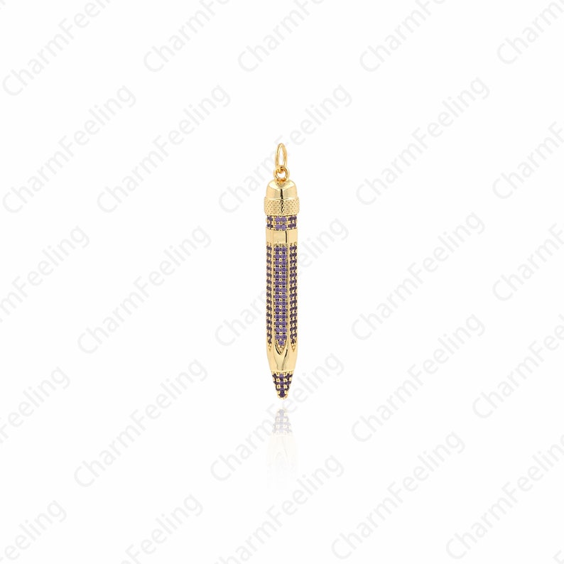 Pu&ograve; includere: Un ciondolo a forma di matita in oro con pietre di zircone cubico viola. Il ciondolo &egrave; progettato per assomigliare a una matita con una punta appuntita e una fascia metallica attorno al centro.