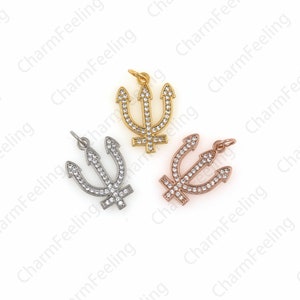 May include: Three trident charms with clear crystal accents. The charms are made of gold, silver, and rose gold metal.
