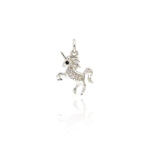 May include: A silver unicorn charm with clear and black rhinestones. The unicorn is standing on its hind legs with its head held high.