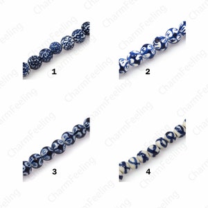 Peut inclure: Quatre brins de perles en céramique bleu et blanc avec un motif floral. Les perles sont enfilées sur un fond blanc.