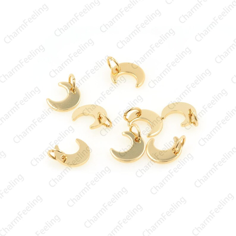 May include: A group of ten gold-coloured crescent moon charms with a jump ring for attaching to jewellery.