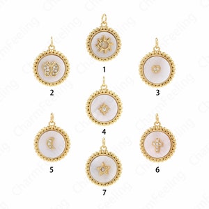 Puede incluir: Siete colgantes de tono dorado con incrustaciones de nácar blanco y detalles de cristal. Los colgantes presentan diferentes diseños, que incluyen un sol, una mariposa, un corazón, una estrella, una luna creciente, una cruz y una estrella de cinco puntas.