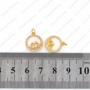 May include: Two gold-tone metal charms with clear rhinestone accents. The charm on the left features a wave design. The charm on the right features a mountain design. Both charms are approximately 2.5 cm in diameter.