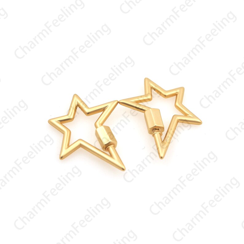 May include: Two gold-colored star-shaped clasps. Each clasp features a five-pointed star design with a screw closure mechanism. The clasps are made of a shiny, metallic material and are set against a white background. The text "CharmFeeling" is visible in the background.